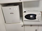 a microwave and a small refrigerator in a small room