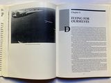 an open book with a picture of a plane flying in the sky