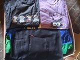 trois paires de jeans dans une boîte posée par terre