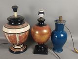 trois vases et une lampe posés sur une table