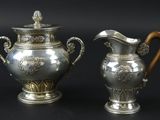 deux vases en argent posés l'un à côté de l'autre sur une table