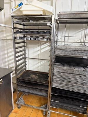 une étagère métallique contenant plusieurs plateaux de nourriture