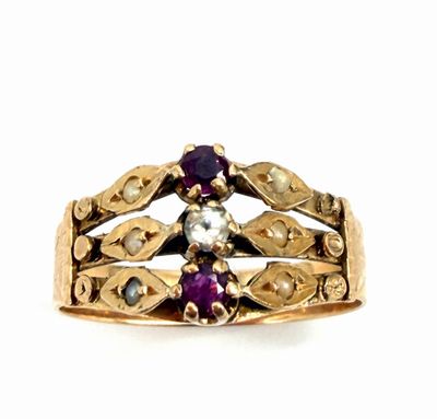 an image of a close up of a gold ring with purple stones