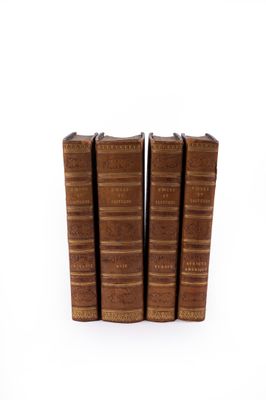 quatre vieux livres empilés les uns sur les autres sur une surface blanche