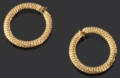 deux paires de boucles d'oreilles créoles en or posées sur un fond noir