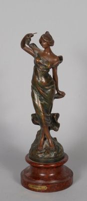 bronze statue of a woman holding a bird on a wooden base