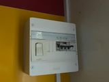 a white electrical panel mounted on a yellow wall