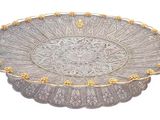 an image of a silver plate with gold decorations on it
