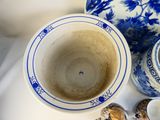 a blue and white vase sitting next to a blue and white bowl