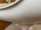 a close up of a white chair with a green seat