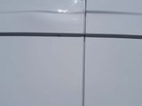 a close up of a white van with a blue sky in the background