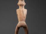 an image of a wooden statue of a man standing on one leg