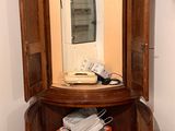 a corner cabinet with a mirror and a phone in it