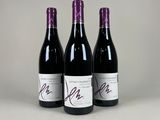 trois bouteilles de vin sont alignées sur une table