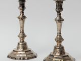 pair of antique silver candlesticks on a white background
