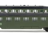 three green train cars sitting side by side on a white surface