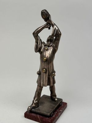 figurine en bronze représentant un homme tenant un oiseau, posée sur un socle en marbre