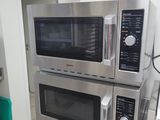 two microwaves stacked on top of each other in a kitchen