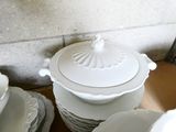 a stack of white plates and bowls on a table