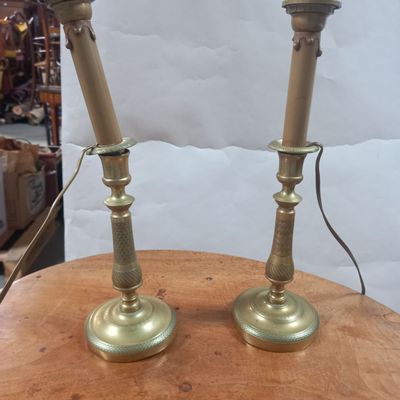 pair of brass candles on a wooden table in a store