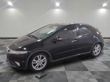 une photo d'une Honda Civic noire posée sur un sol à damier