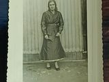 an old photo of a woman standing in front of a wall