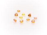 a group of yellow and orange gems on a white surface