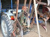 a tractor with a plow attached to it in a garage