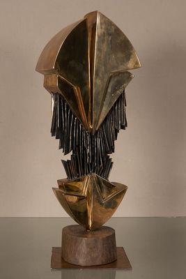 sculpture représentant une tête en bronze ornée de franges, posée sur un socle en bois