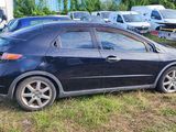 a black car that is parked in the grass
