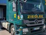 a large green truck parked in front of a building