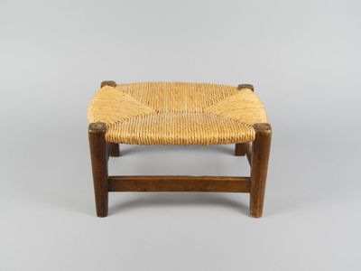 un petit tabouret en bois avec une assise tressée sur fond blanc