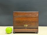 a small wooden box with a green apple next to it