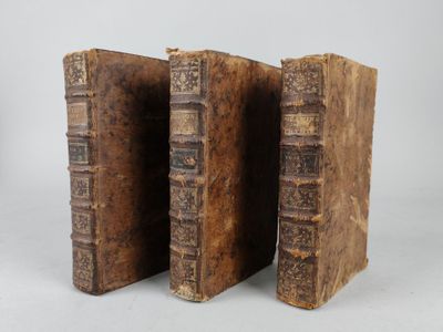 two old books sitting on top of each other on a white surface