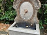 a stone water fountain with a bird on top of it