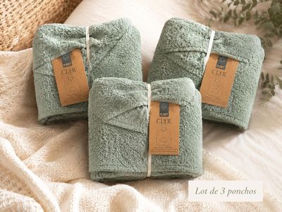 three towels are wrapped up on a bed with a tag on them