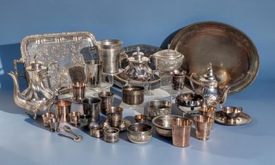 a lot of silverware on a table with a blue background