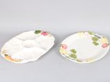 two plates with flowers on them sitting on a gray surface