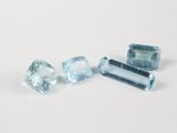 trois pierres précieuses de topaze bleue posées sur une surface blanche