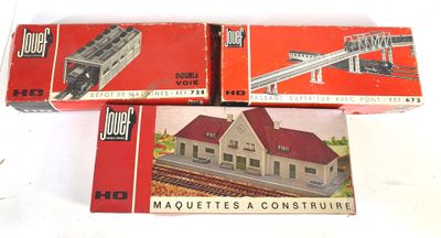 trois trains miniatures dans leurs boîtes, empilés les uns sur les autres