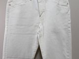 a pair of white jeans hanging on a hanger on a wall