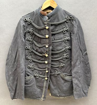une vieille veste militaire accrochée au mur à l'aide d'un cintre en bois