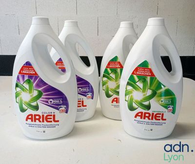 four bottles of ariel liquid sitting on top of a counter
