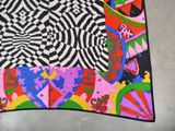 a multicolored scarf on the floor with a black and white background