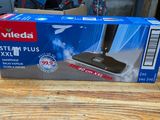 the box of a vacuum mop is on a wooden table