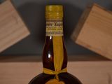 a bottle of liquor sitting on top of a wooden table