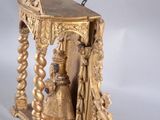 a gold statue of a woman and a bell on a table