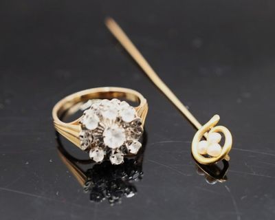 une image représentant une bague en or ornée d'une perle et d'un bâton