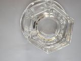 a clear glass object on a white surface