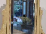 a mirror sitting on top of a table next to a vase